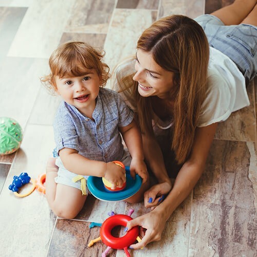 Happy baby playing with mom | Canales Flooring Inc.